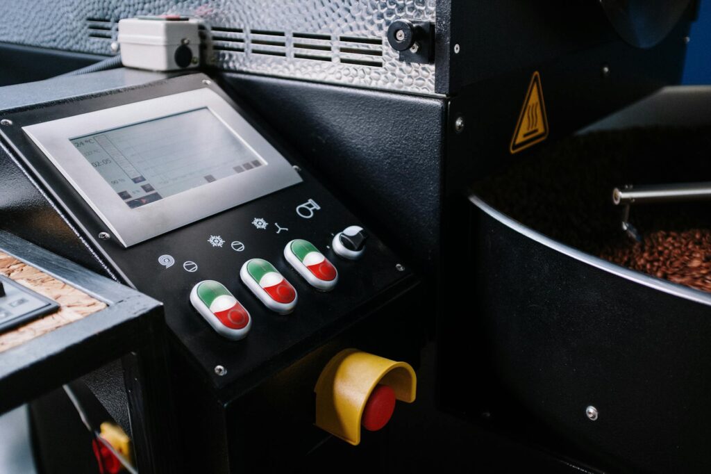 Detailed view of a coffee roaster control panel showing buttons and beans.